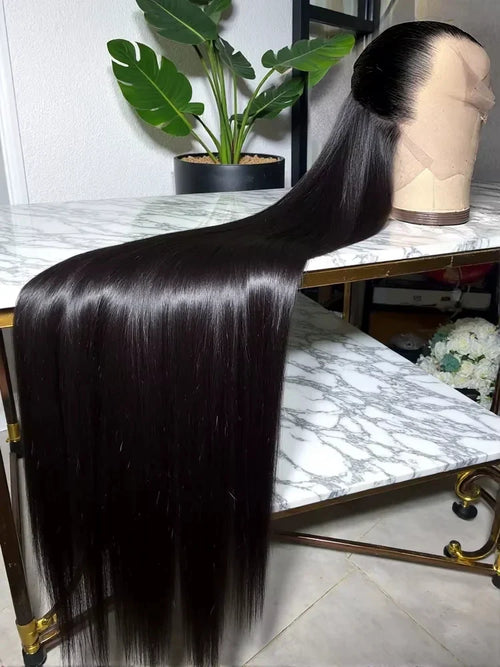 Extra-long natural black straight lace front wig on a mannequin head, laid across a marble table